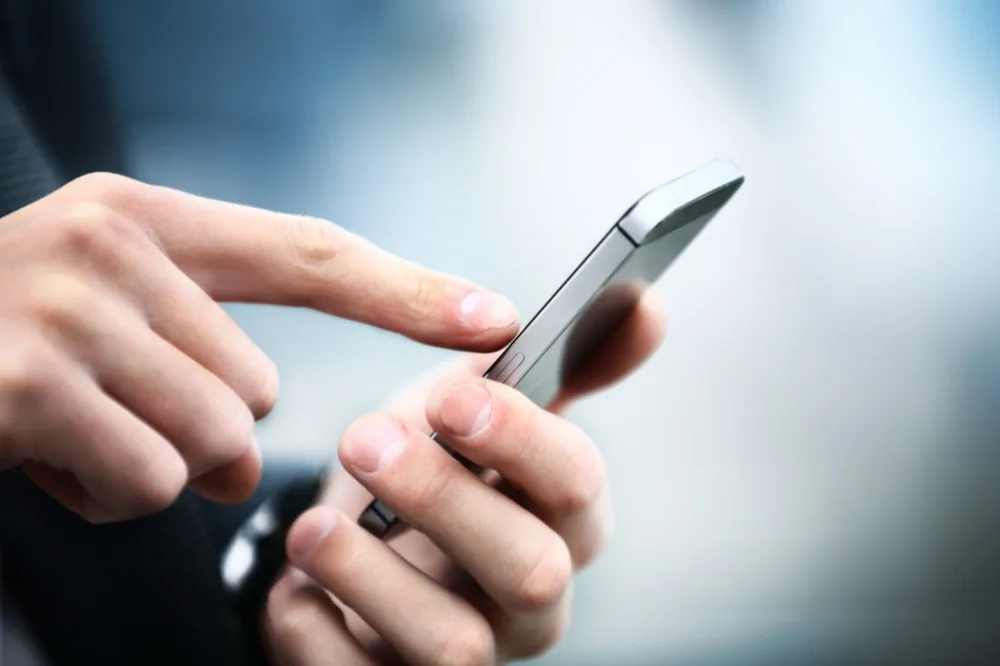 スマートフォンで査定連絡を確認する様子